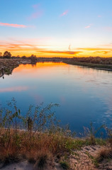 Fototapeta na wymiar River at sunset sky background