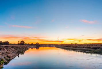 Naklejka na ściany i meble Beautiful horizon over the river at sunset time