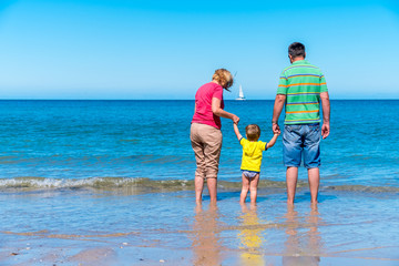 Grandfather and grandmother with grandson holding hands