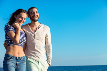 Couple walking on beach. Young happy interracial couple walking on beach.