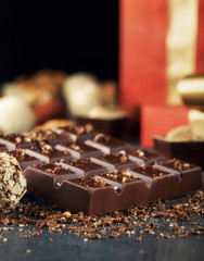 Chocolate bar with different chocolate candy and red gift box