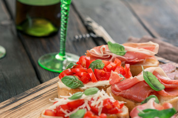Various Italian appetizers for wine on wooden board