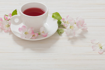 Fototapeta na wymiar Red tea with flowers on white wooden background