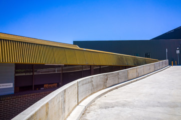 Concrete ramp alongside a building. Cement slope near an office building. Service route in a hospital.