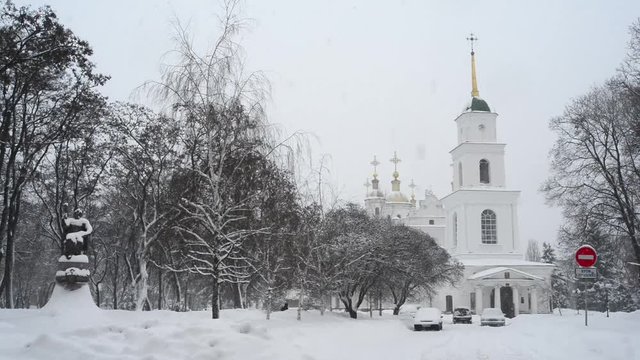 Winter. It is snowing. View of the Cathedral Square in Poltava in Ukraine. On the square are the Cathedral with a bell tower and a monument to the outstanding Ukrainian Hetman Ivan Mazepa.