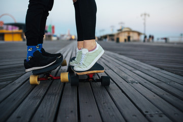 Longboarding couple together, romantic, feet only