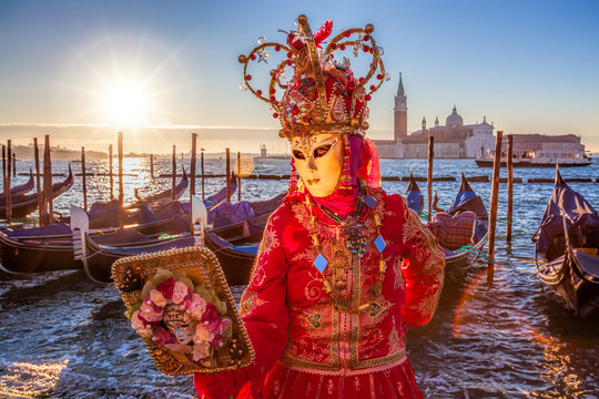 Carnival masks with mirror against dondolas in Venice, Italy