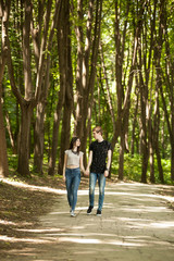 Fototapeta na wymiar Young couple taking a walk in the forest