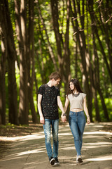 Couple walking outside in the forest and holding hands