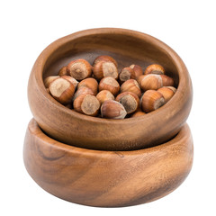 Hazelnuts in a wooden bowl isolated on white background.