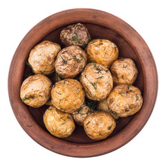 Baked potatoes with spices in an old clay bowl.