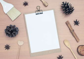 Blank notepad with pine cones on wooden table background