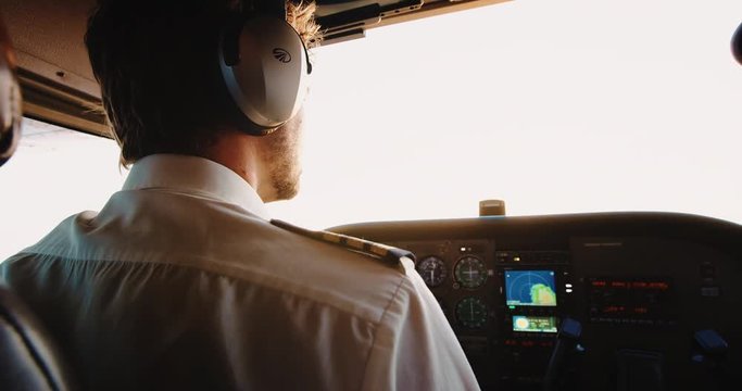 Cockpit view of young male pilot flying small plane with beautiful sunrise light shot in 4K slow motion on RED camera