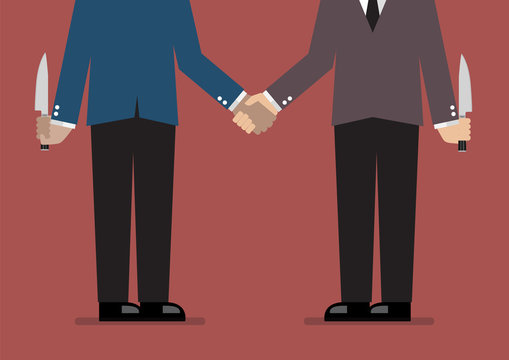 Closeup of business handshake with a knife hidden behind
