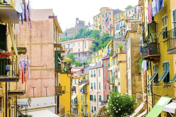 Riomaggiore village, La Spezia, Liguria, northern Italy. Colourful houses on steep hills,castle with clock,laundry on balconies.Part of the Cinque Terre National Park and a UNESCO World Heritage Site.