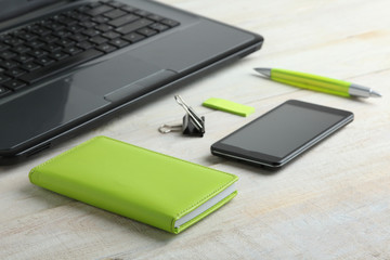 Phone, laptop, pen, notebook on the office table in the color green Pantone 2017