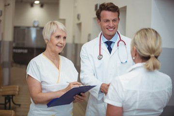 Fototapeta premium Doctor shaking hand with nurse in corridor