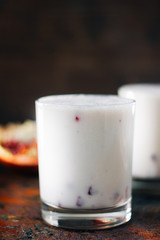 Traditional indian drink - lassi - cold yougurt dessert with the pomegranate seeds.