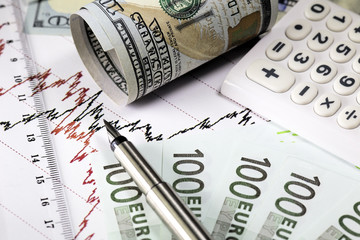 Stock market coffee prices chart. Red and black lines on the diagram. Rolled us  dollar bill. Ruler,fountain pen and calculator on the graph. euro bills.coffee stock market trading. Macro.
