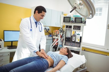 Doctor examining the stomach of a female patient