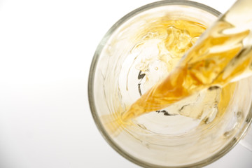Pouring tea into glass cup, isolated, top view
