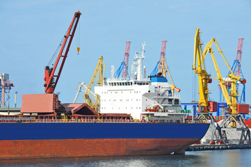 Obraz premium Bulk cargo ship under port crane