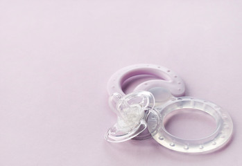 transparent pacifier on pink background