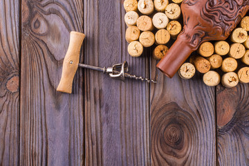 bottle of wine with corks on wooden table background