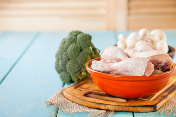 raw chicken legs, mushrooms and vegetables on a table, selective focus, copy space