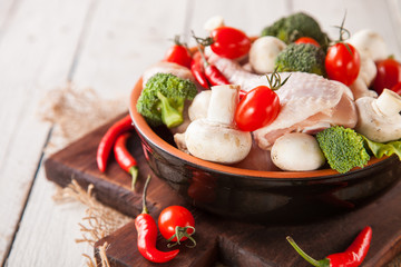 raw chicken legs, mushrooms and vegetables on a table, selective focus, copy space