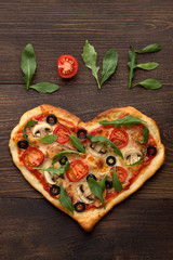 Valentines day pizza in heart shape with text love on dark wooden background. - 133489318