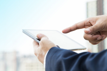 Hands of businessman working on digital tablet outdoor