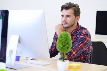 Rear View Of A Businessman in startup office Analyzing Graph On Computer