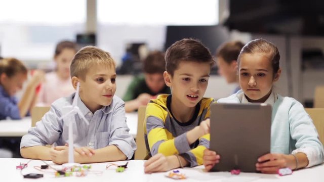 kids with tablet pc programming at robotics school