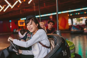 Tuinposter Happy young girl driving a bumper car © Jacob Lund