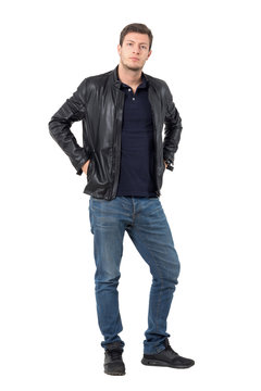 Young casual man in leather jacket put hands in pockets looking at camera. Full body length portrait isolated over white background.