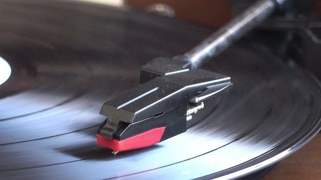 Turntable player,dropping stylus needle on vinyl of a spinning record playing.