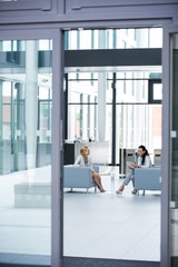 Businesswomen sitting in armchair and having a conversation