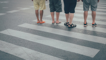 Motion of pedestrian zebra crossing or crosswalk in asia. Feet of the pedestrians crossing on city street closeup.