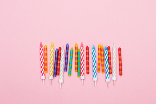 Multi-colored striped candles for birthday in line. Minimalism. Flat lay.