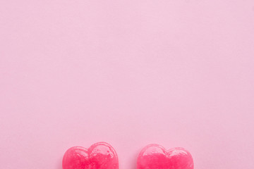 two Pink Valentine's day heart shape lollipop candy on empty pastel pink paper background. Love Concept. Knolling top view. Minimalism colorful hipster style.