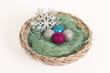 Christmas balls lying in a basket in the nest
