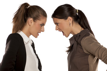 Two young angry woman yelling at each other