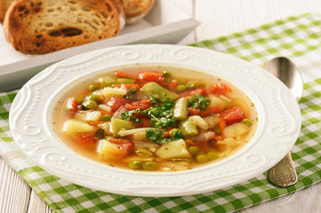 Vegetarian vegetable soup on wooden bakcground.
