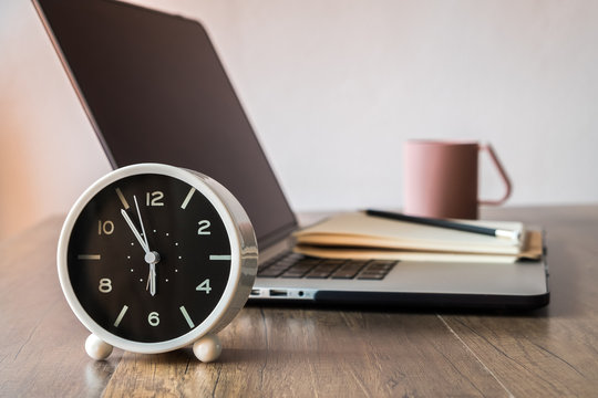 Working Desk, Office And Home Office Concept. With Laptop, Pencil, Clock, Milk Cup On Wooden Table.