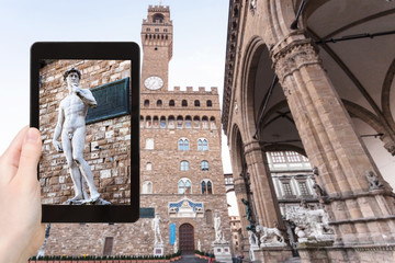 tourist photographs statue near palazzo vecchio