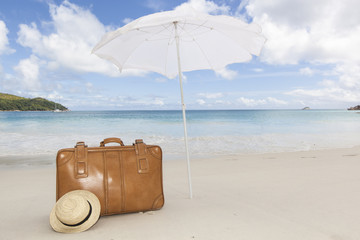 brown suitcase under sunshade