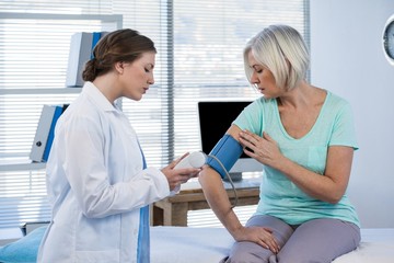 Female doctor checking blood pressure of a patient