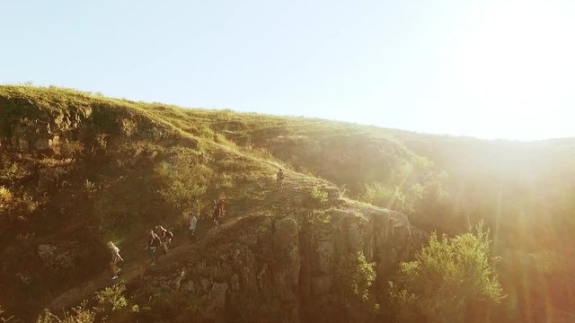 Tourists going down rocky trail in prairie. Panoramic flyover drone view in slowmotion