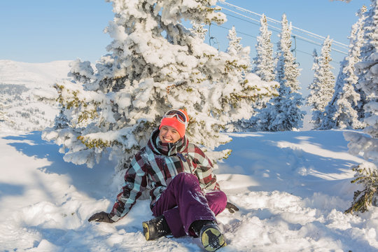 Portrait of young smiling woman sitting on snow